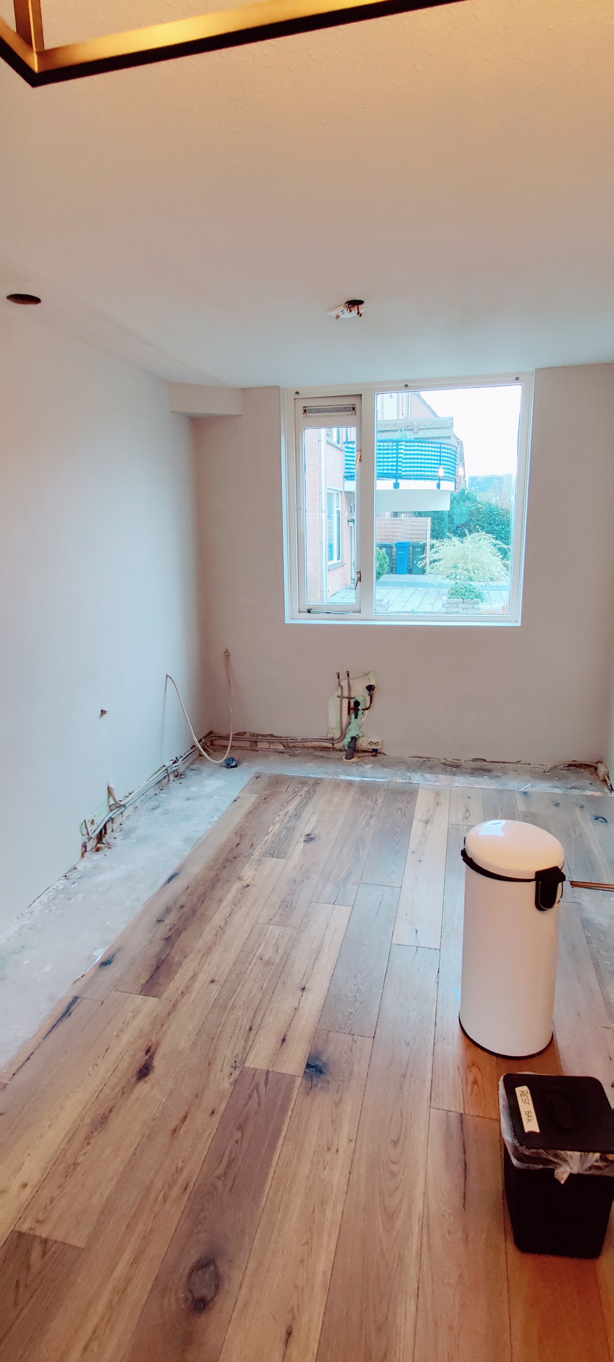 Lege keukenruimte voor de montage, met leidingen klaar in de wand