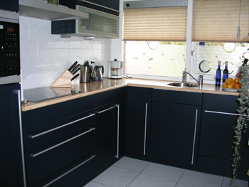 Donkerblauwe keuken met houten werkblad